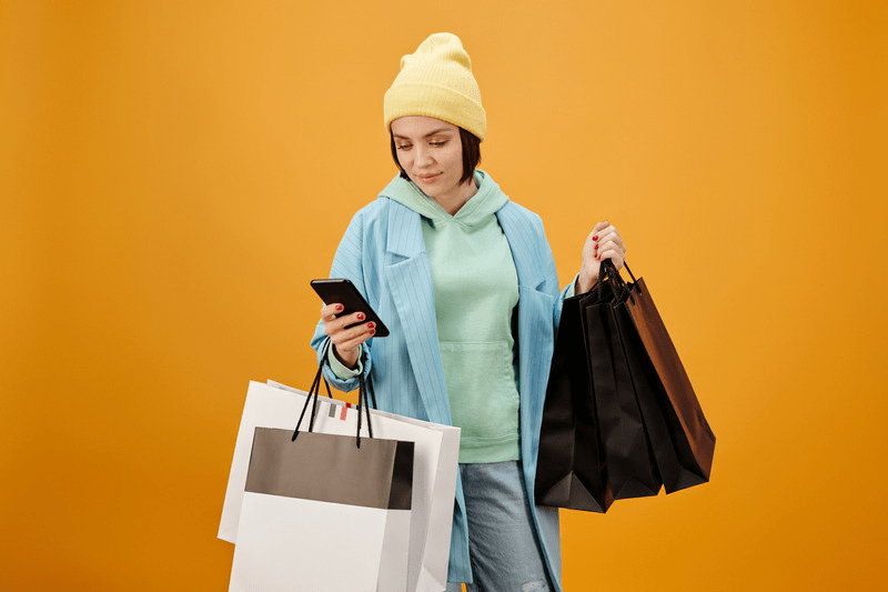 Woman with shopping bags looking at her smartphone