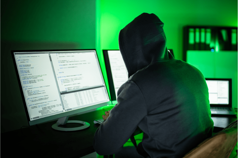 stereotypical hacker behind a computer screen