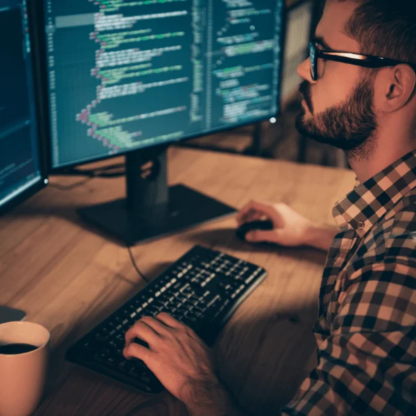 A programmer sitting at the computer equipped with Linux OS