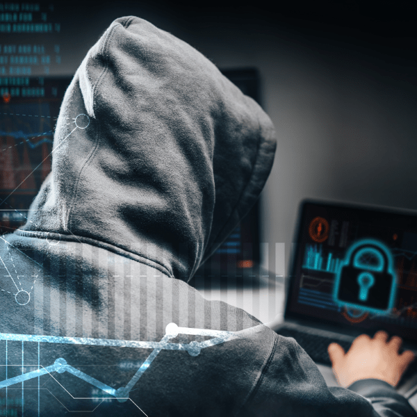 hooded person using a laptop with the symbol of a lock on the screen, representing activities of cybercriminals