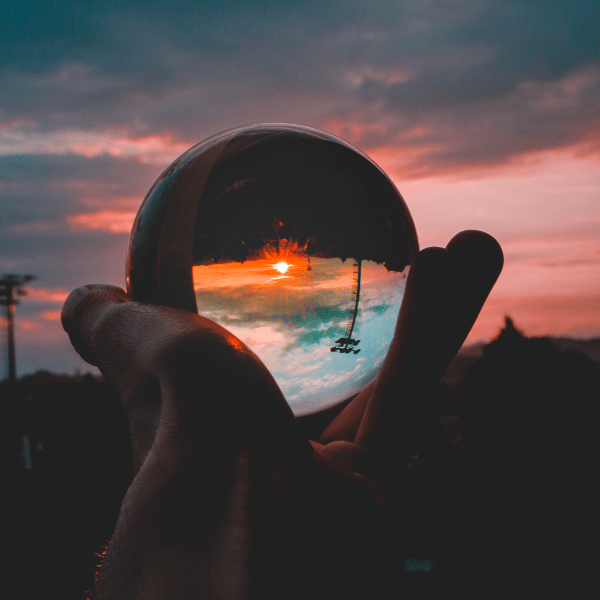 a hand holding a transparent glass ball